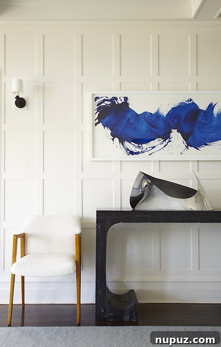 Hallway with exquisite architectural details, intricate wall paneling, and a unique console table, designed by Brian Brady.