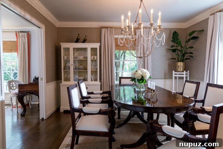 Step Inside Greensboro's Charming Oasis 6 Charming white brick exterior of the Adcox home in Irving Park, featuring pale blue-gray shutters, a well-maintained garden, and a classic picket fence.