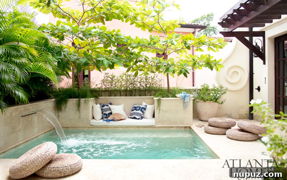 Costa Rica Dream Home Unveiled 13 Inviting poolside area with chic lounging space, waterfall, and blue and white pillows at a Costa Rican beach house.