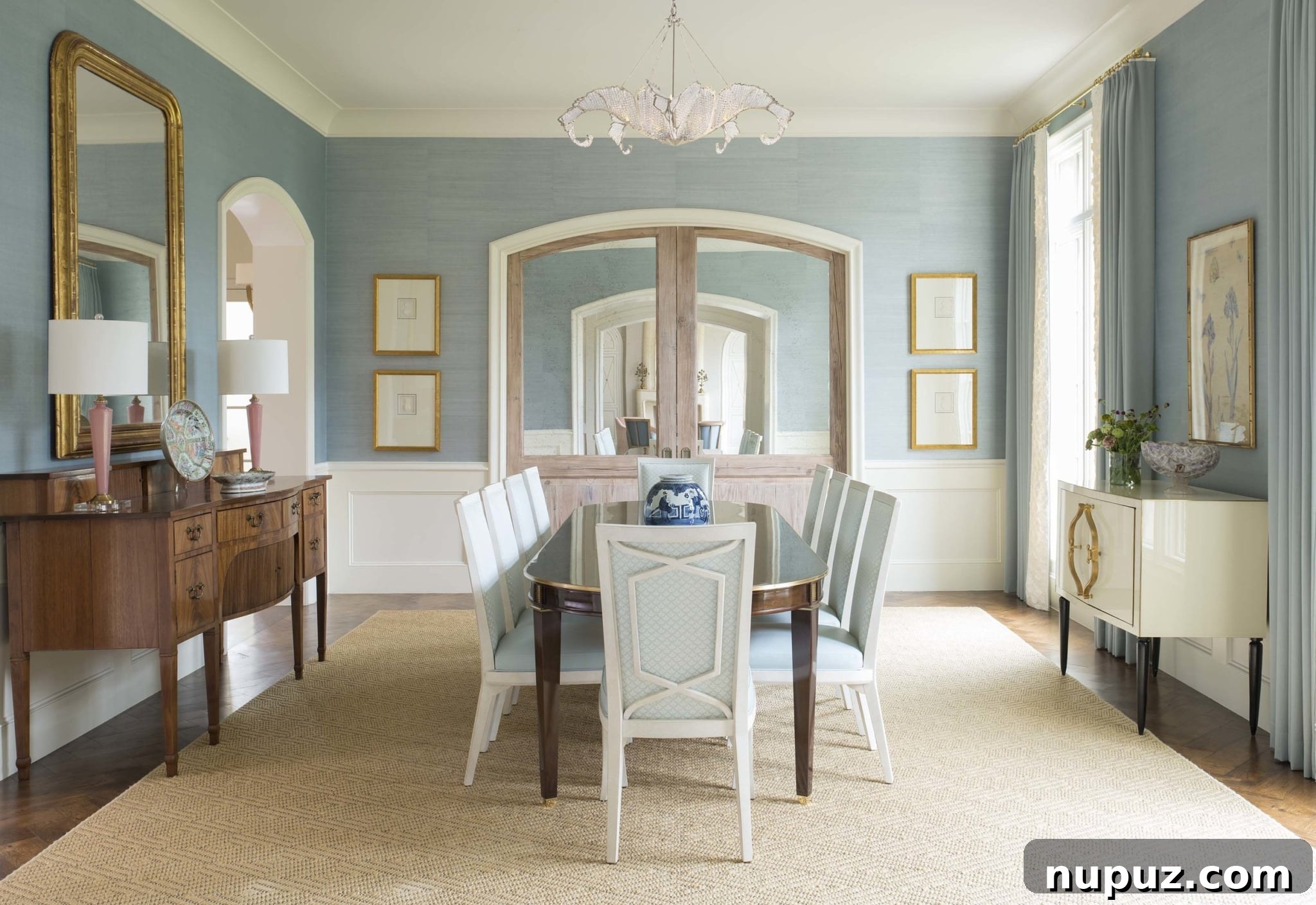 Elevate Your Dining with Jenkins Interiors 2 Elegant dining room with a long wooden table, plush upholstered chairs, and a grand chandelier, bathed in natural light from large windows.
