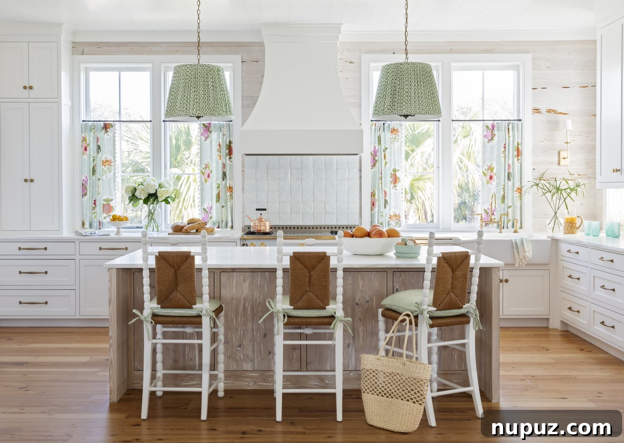 Kara Miller Crafting Kitchens of Unrivaled Beauty 2 A bright and spacious kitchen by Kara Miller, featuring light wood cabinetry, a large central island with seating, pendant lighting, and warm natural textures. The space exudes a welcoming and contemporary farmhouse charm, expertly captured by Brantley Photography.
