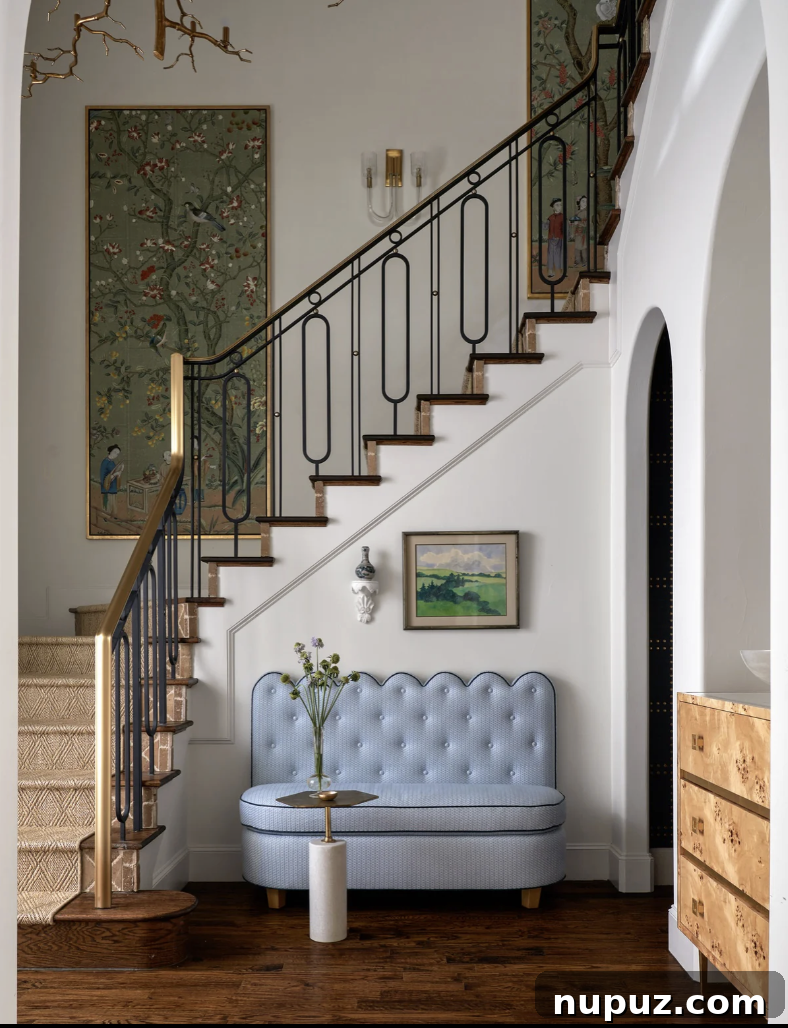 Elegant entry foyer with a scalloped edge banquette and antique chest, showcasing timeless interior design.