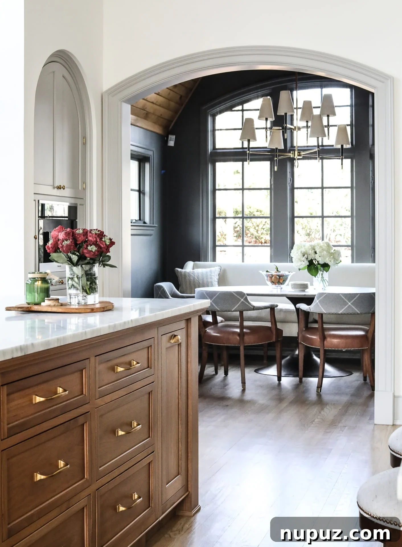 Warm and inviting kitchen with light greige cabinets, elegant range hood, and textured backsplash, creating a soft neutral aesthetic by Park and Oak Design.
