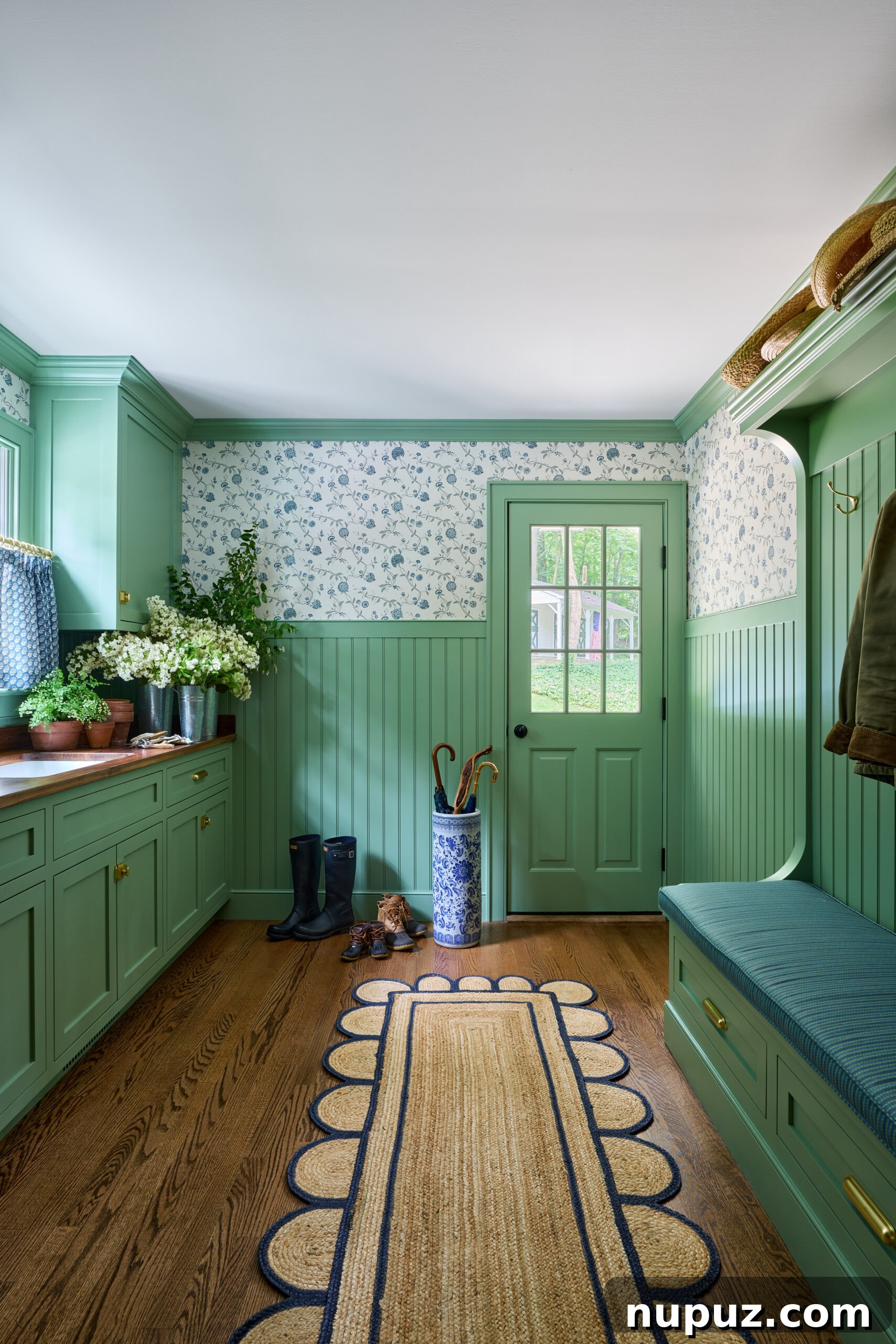 Beautiful green mudroom by Jennifer Hunter, featuring a scalloped seagrass rug for added texture and charm, photographed by Kirsten Francis Photography.