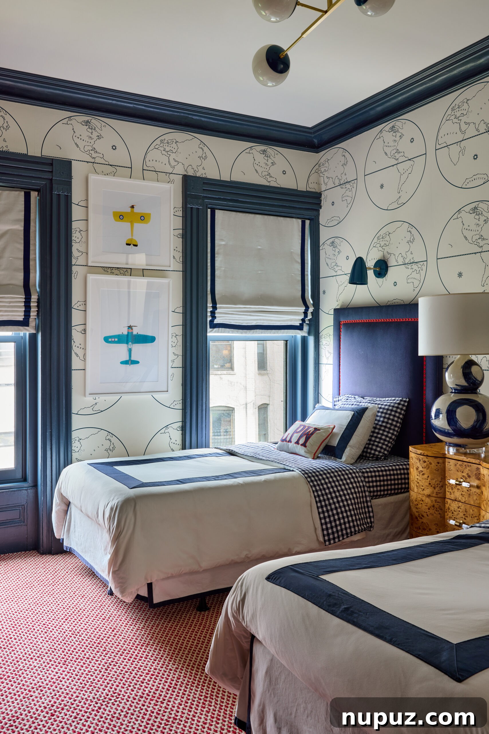 Charming boys' bedroom by Jennifer Hunter, featuring map wallpaper and airplane art, photographed by Kristen Francis.