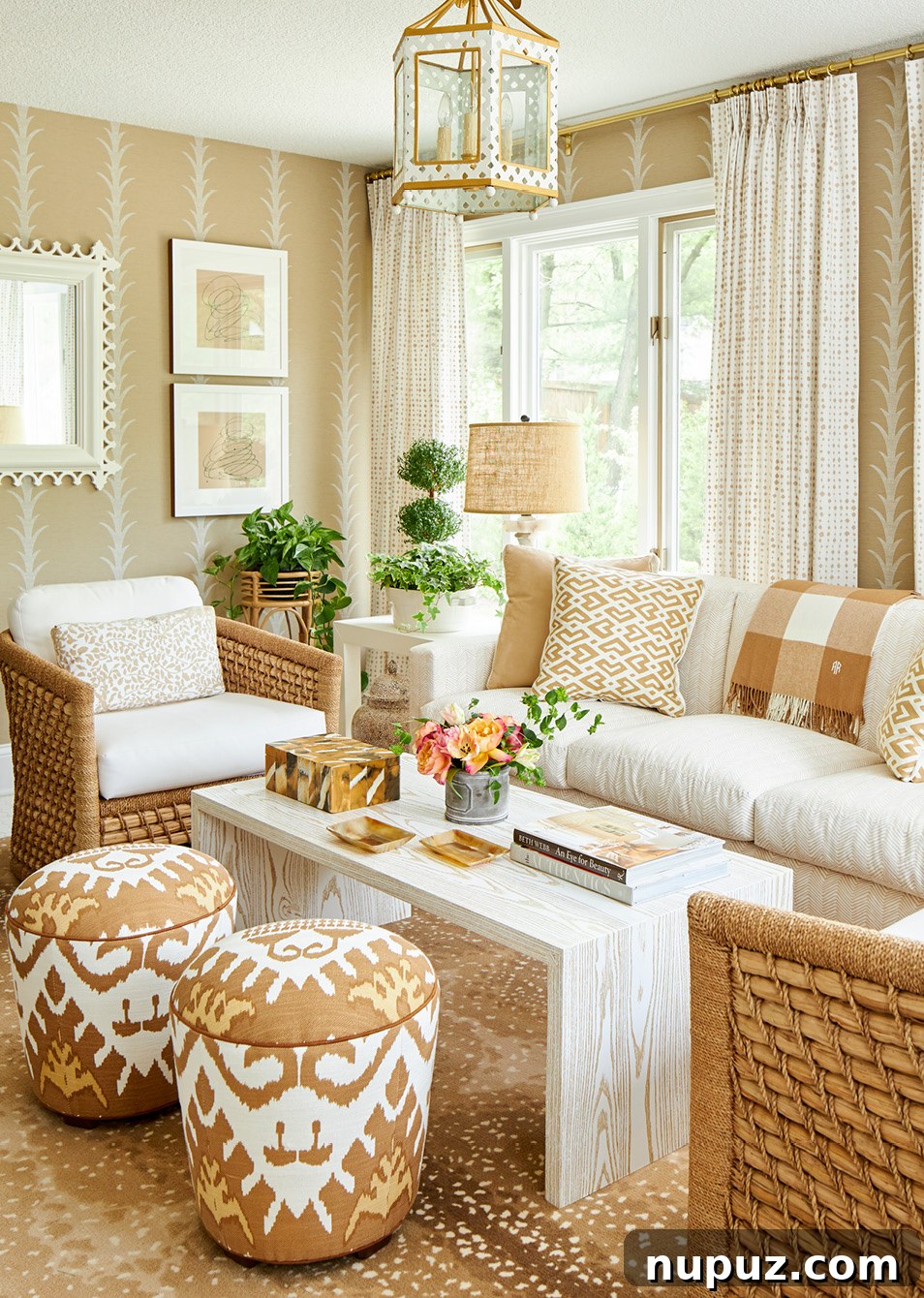 Elegant living room featuring neutral furnishings, a classic fireplace, and a striking Schumacher acanthus leaf wallpaper accent wall, designed by Amanda Reynal and photographed by Adam Albright.