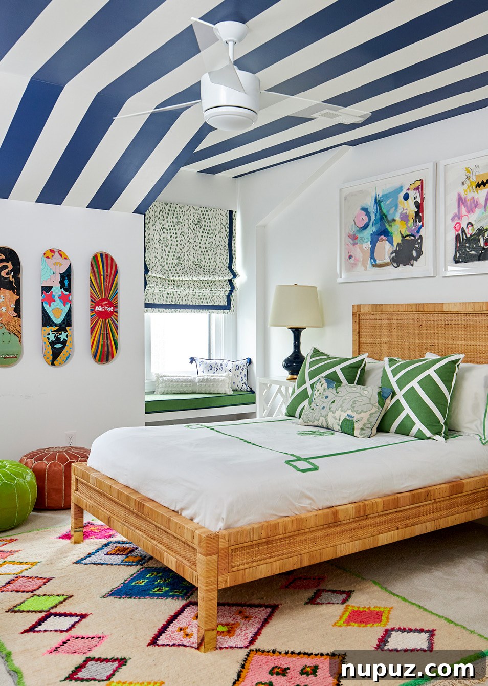Teenager's bedroom featuring a unique blue and white stripe wallpaper on the ceiling, skateboard art on the walls, and a cool, personalized vibe by Amanda Reynal.