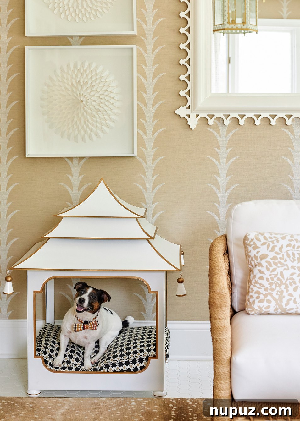 Inviting neutral living room with a decorative fireplace, stylish armchair, and a charming dog bed tucked beneath a console table, designed by Amanda Reynal.