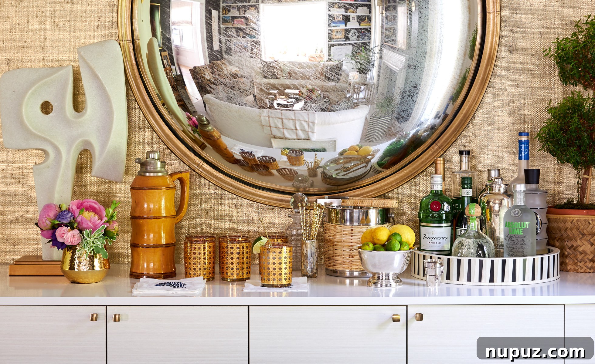 Detailed view of the elegant dining room with warm grasscloth walls, a striking convex mirror, and sophisticated decor by Amanda Reynal.