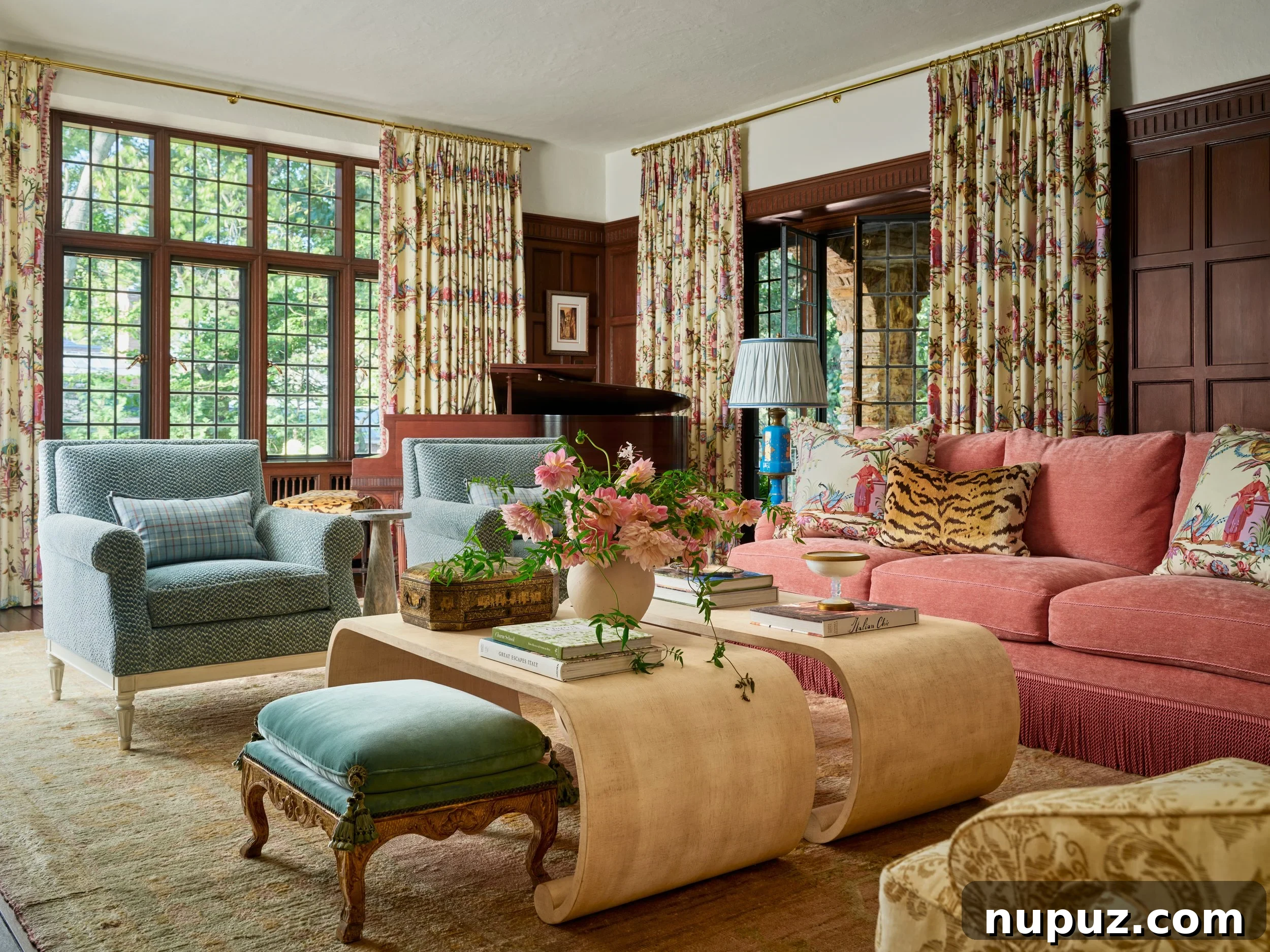 Vibrant living room featuring a salmon-colored sofa and elegant blue velvet chairs by Jenkins Interiors, blending color and texture.