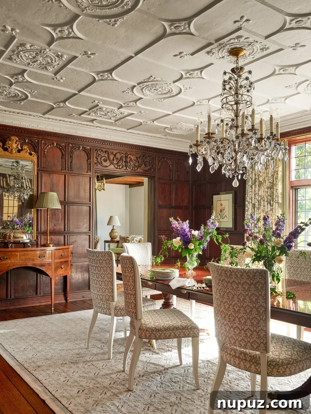 Elegant dining room with intricate architectural ceiling details and a dazzling crystal chandelier, designed by Jenkins Interiors.