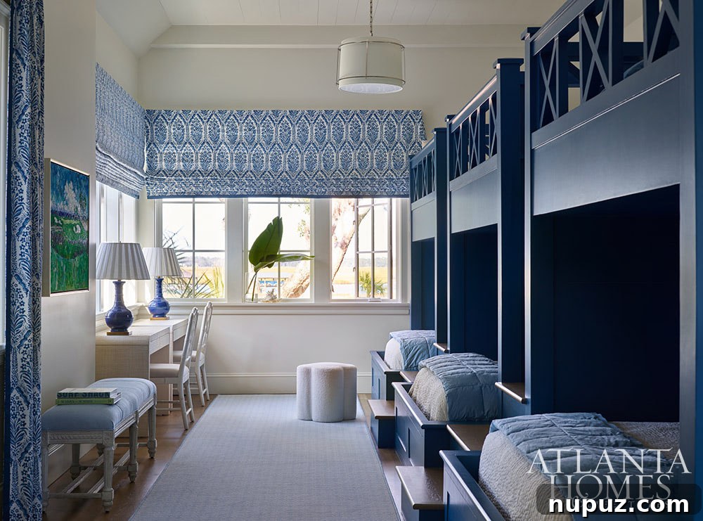 A charming blue and white bunk room in the Sea Island coastal home, creatively designed with triple bunkbeds for comfort and fun, ideal for families and guests.