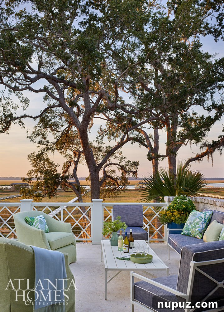An inviting porch area in the Sea Island home, furnished with vibrant blue and green fabric cushions, perfect for enjoying the coastal ambiance outdoors.