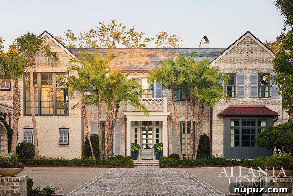 An inviting exterior view of the Sea Island home, showcasing its harmonious coastal architecture and integration with the stunning surrounding landscape.