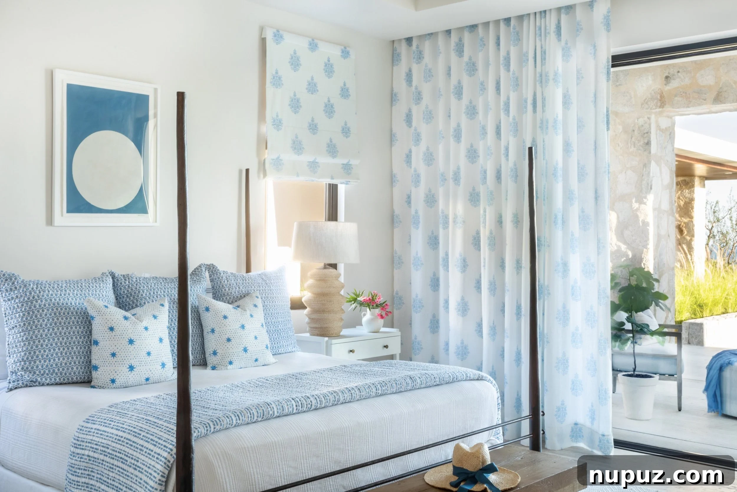 A. Wooten Interiors tarafından tasarlanmış Cabo tatil evinde, ahşap dört direkli yatak ve ayak ucunda bank bulunan mavi beyaz yatak odası. Fotoğraf: Heidi Harris.