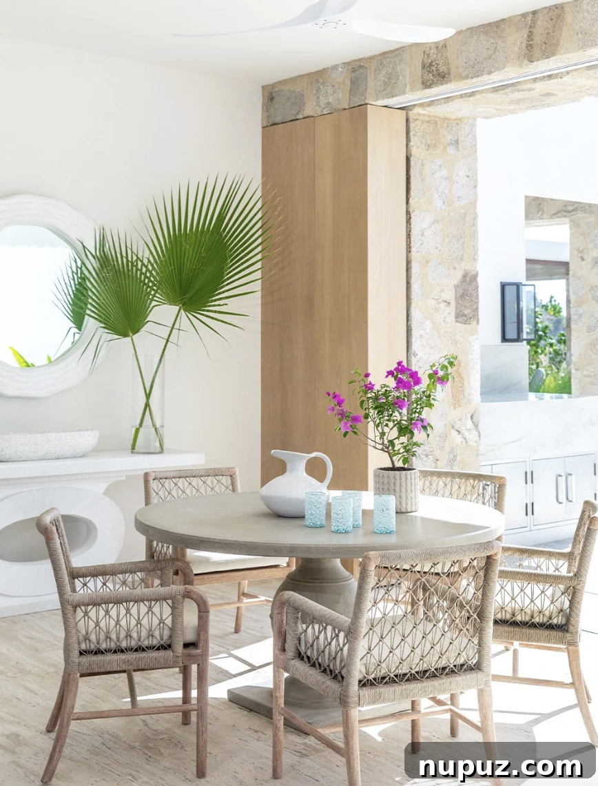 A. Wooten Interiors tarafından tasarlanmış Cabo tatil evinde yuvarlak masa ve hasır sandalyelerle modern yemek odası. Fotoğraf: Heidi Harris.