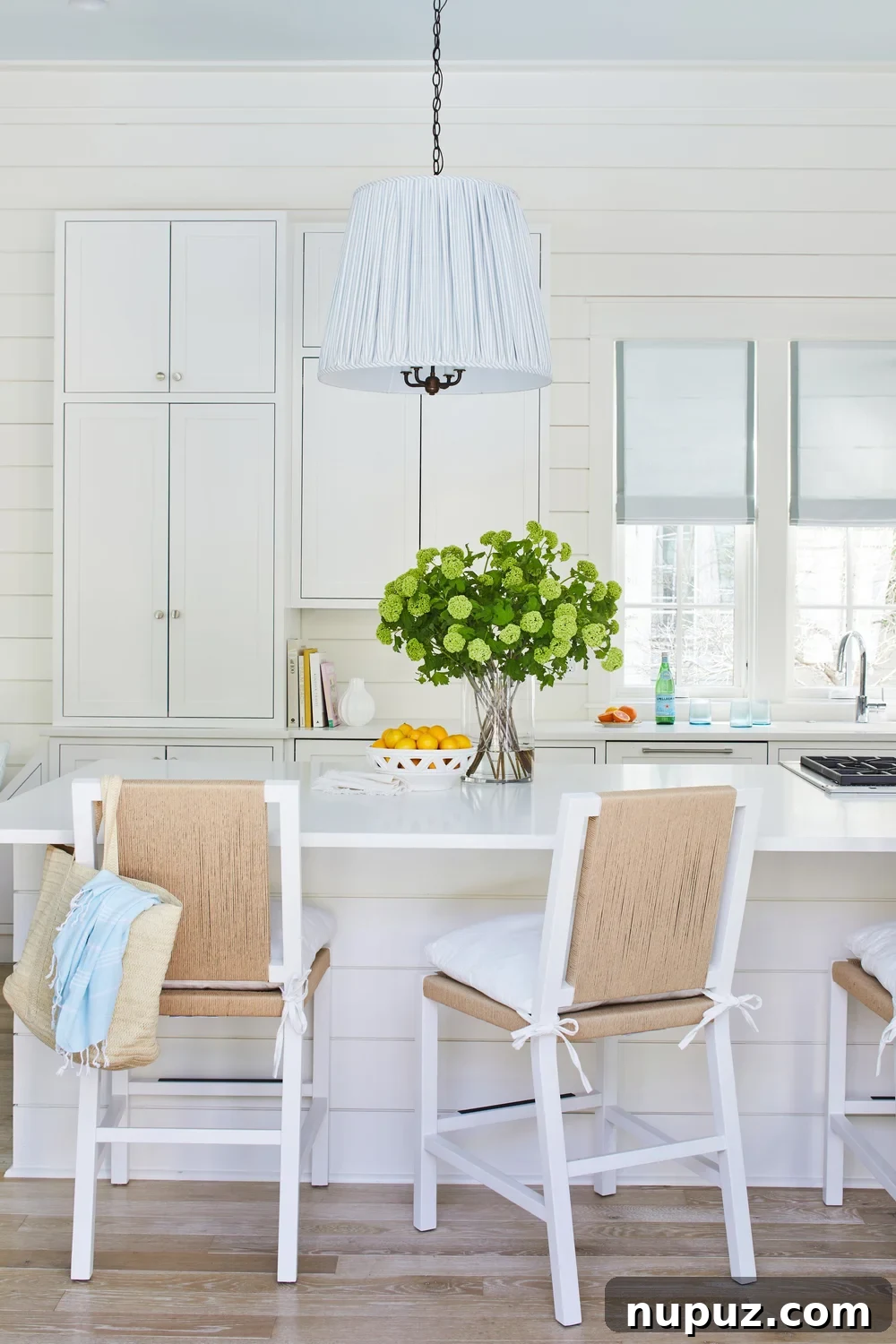 Breezy Blue and White Coastal Bliss 4 Stylish white kitchen featuring classic shiplap walls, designed by Kara Miller, embodying a clean and fresh coastal aesthetic.