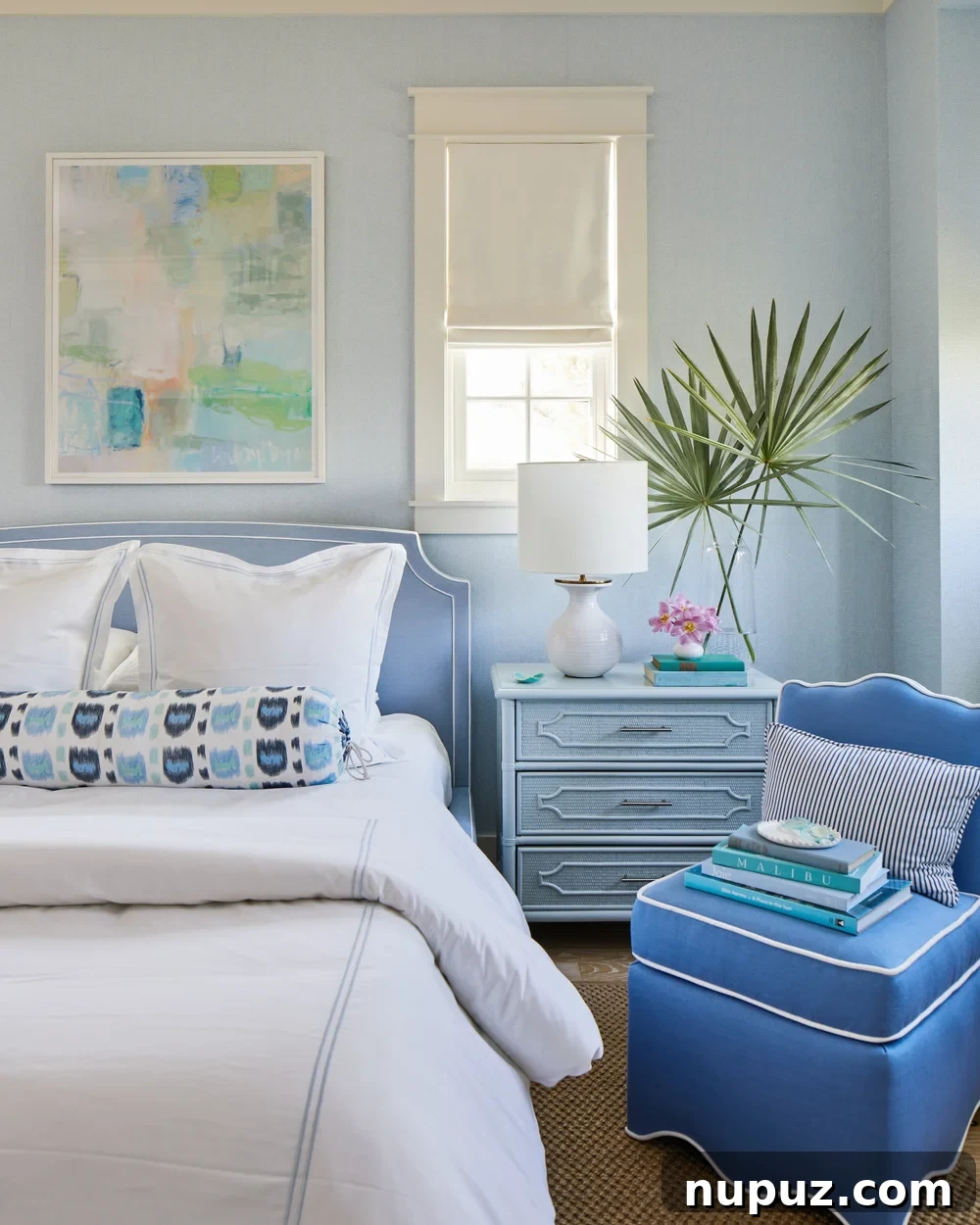 Breezy Blue and White Coastal Bliss 6 Bedroom in a Kara Miller beach house, featuring a cozy long neck roll pillow and elegant abstract art, creating a tranquil blue and white retreat.