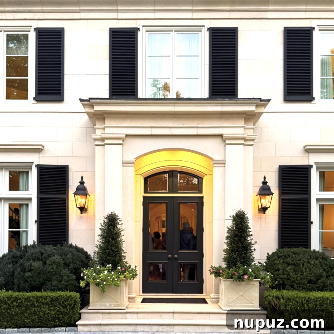 7 Homes Where Boxwoods Command the Landscape 4 Traditional brick home with mature boxwood foundation plantings that soften the facade and integrate the house with its garden surroundings.