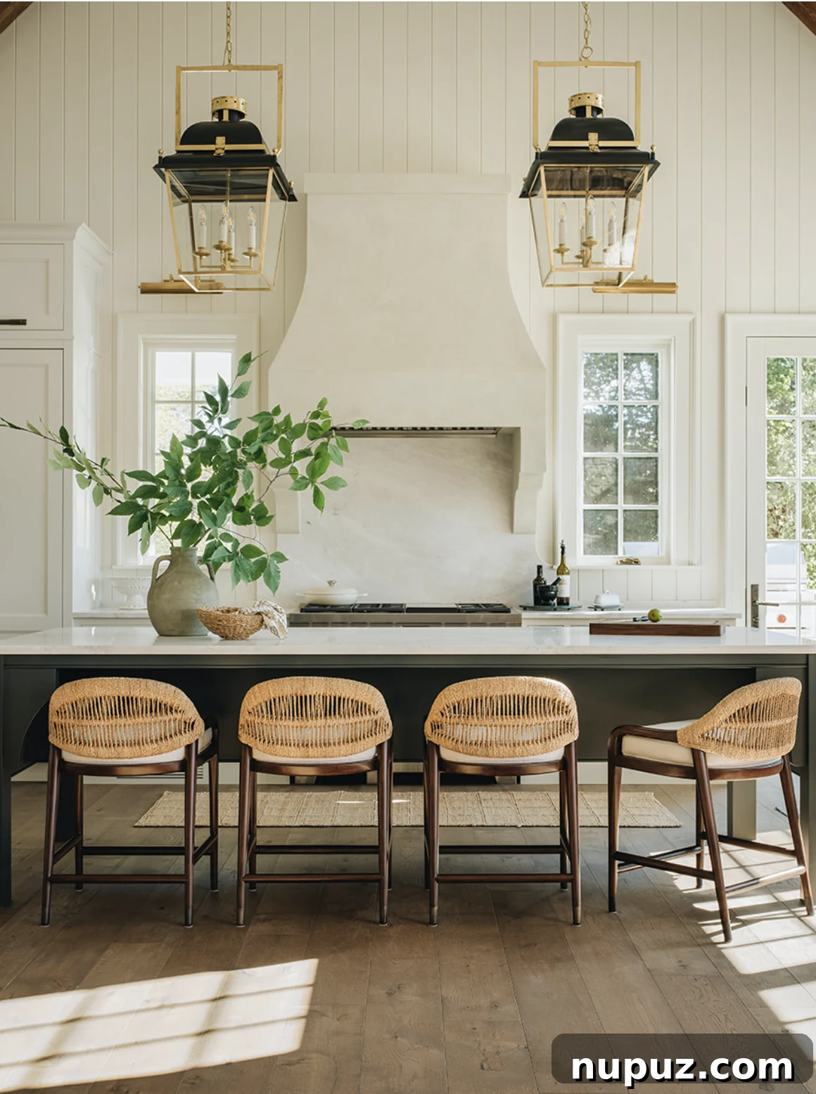 White clapboard kitchen with black and gold lanterns, designed by Jean Stoffer