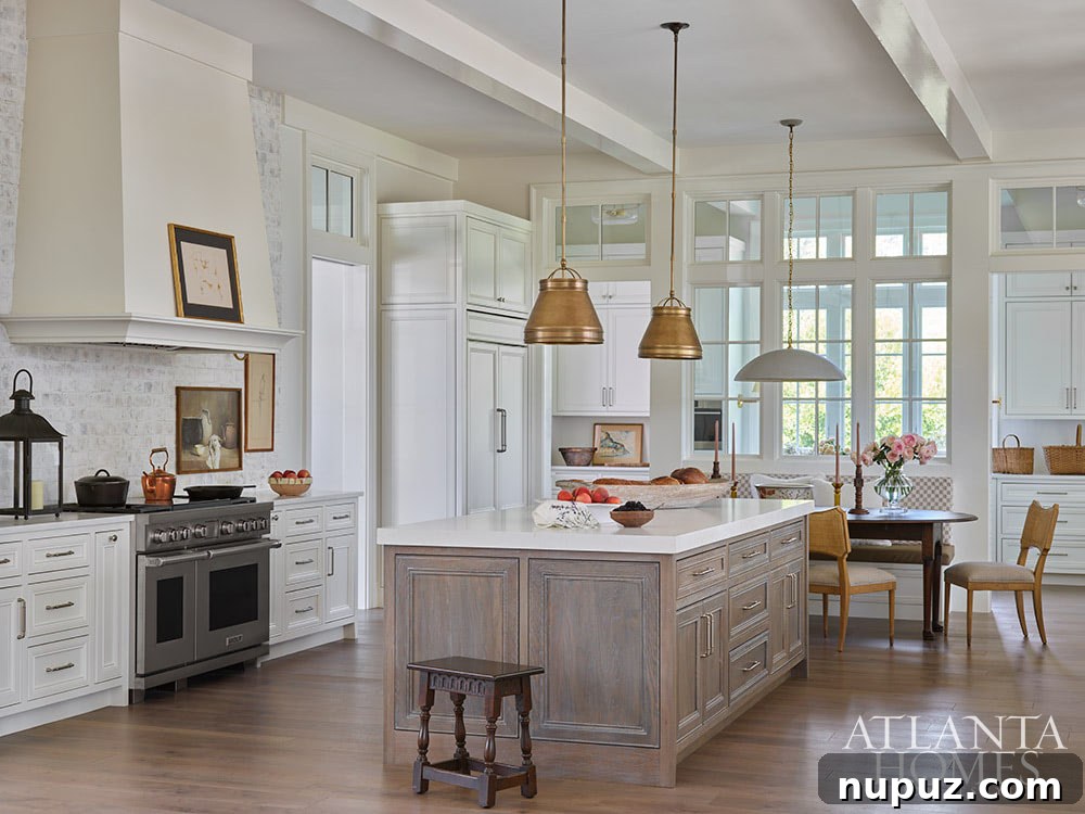 Kitchen with stained island, white cabinets and brass pendants