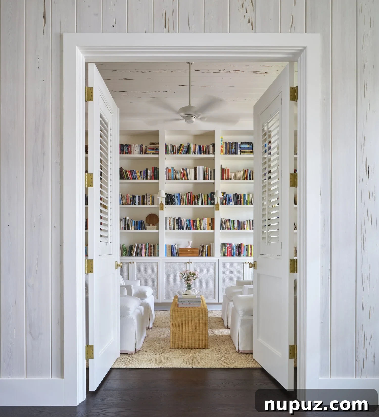Neutral living room with bookcases and white chairs