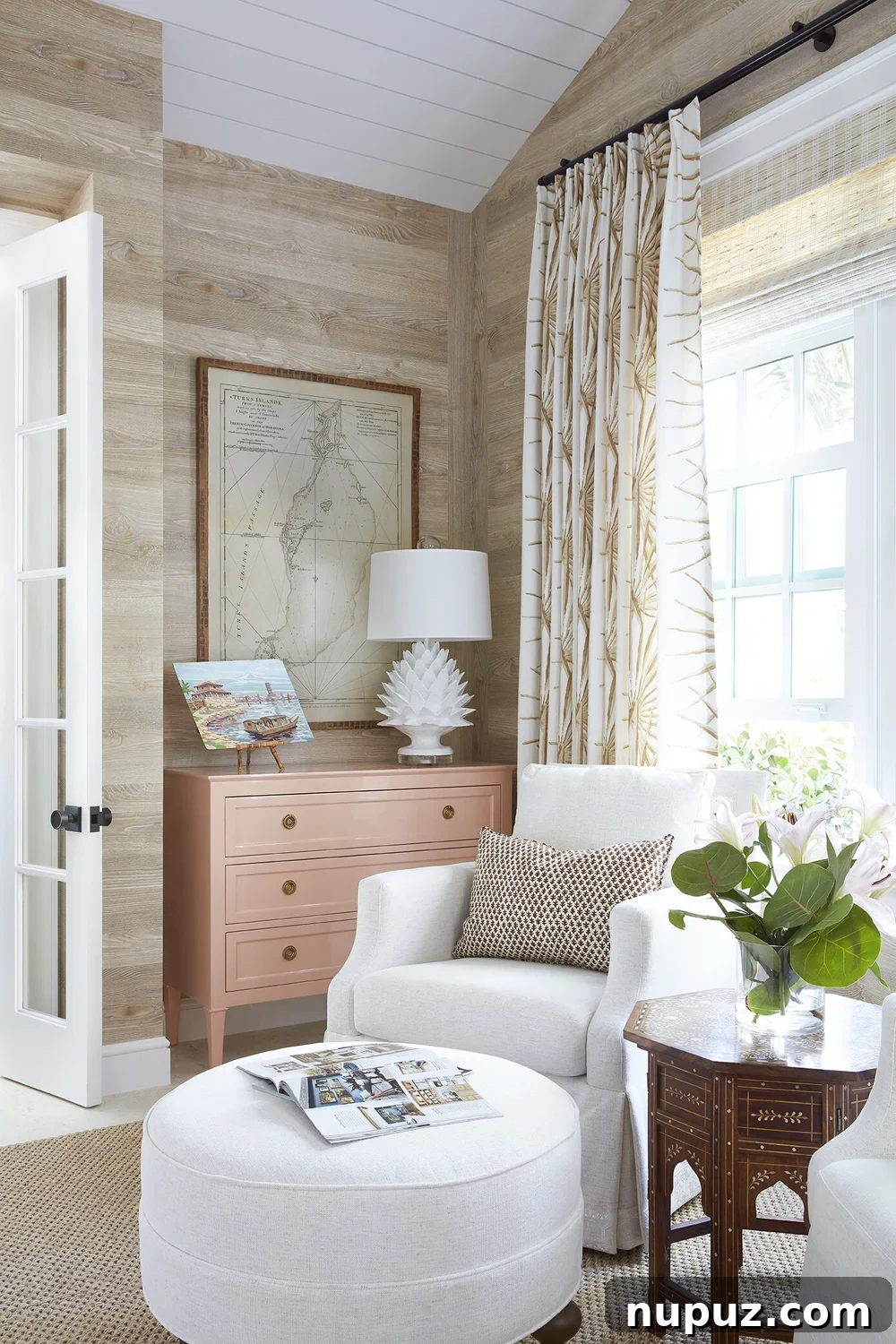 Beautiful neutral living room with blonde wood walls and white club chairs