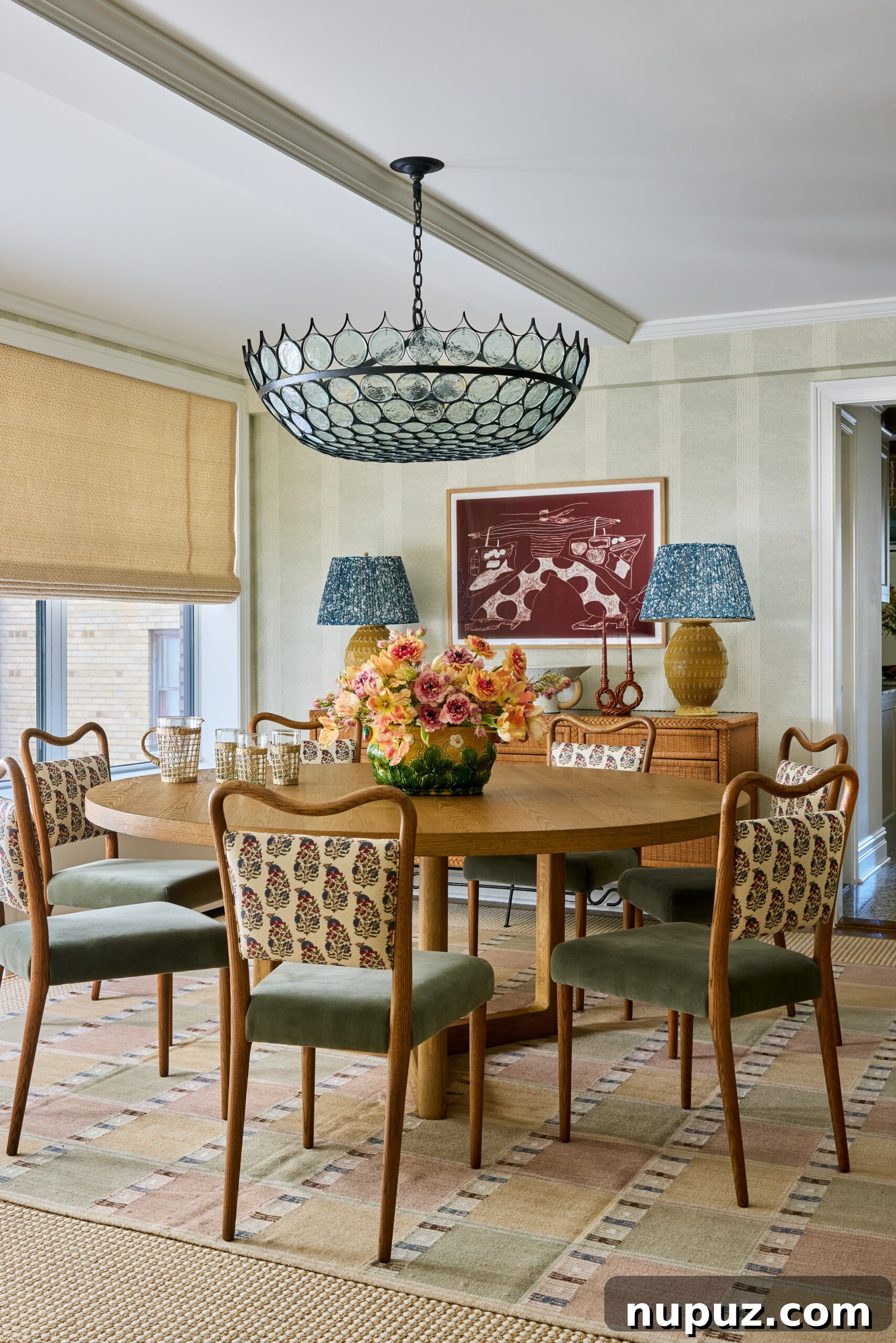 Round dining table in dining room with wallpaper and bamboo shades