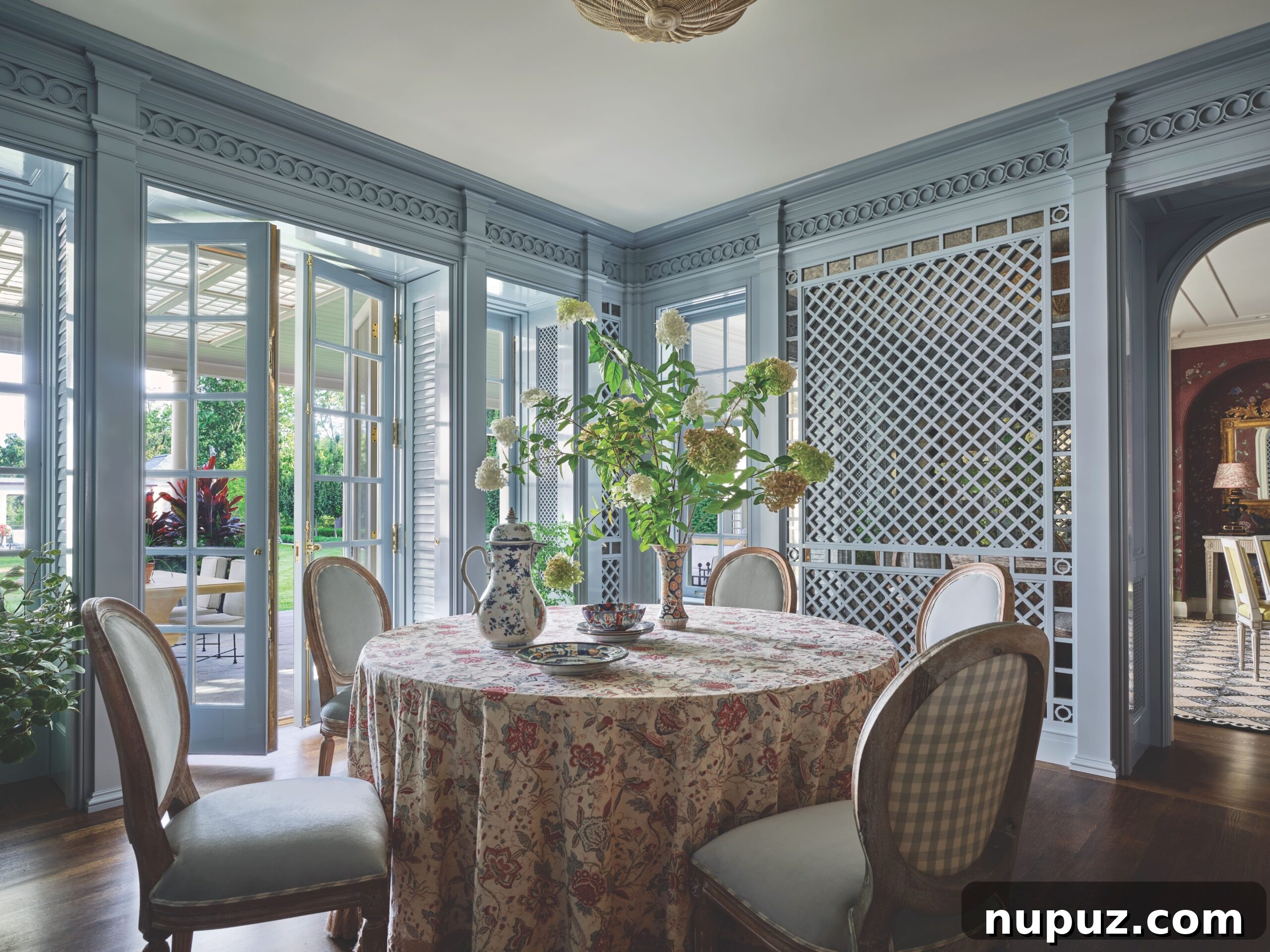 Breakfast room with lattice and round table with French chairs. Love the moody blue color.