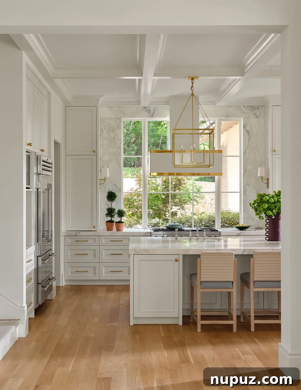 Bright white kitchen with brass hardware and island seating
