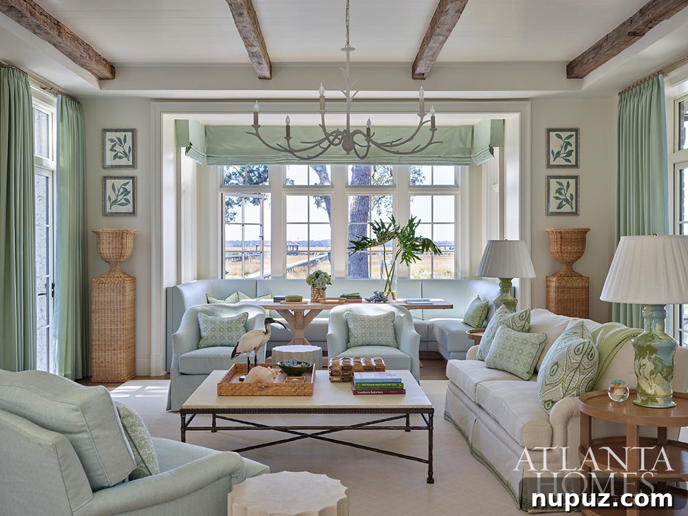 Beautiful living room with wood beams in light blue and white and a water view