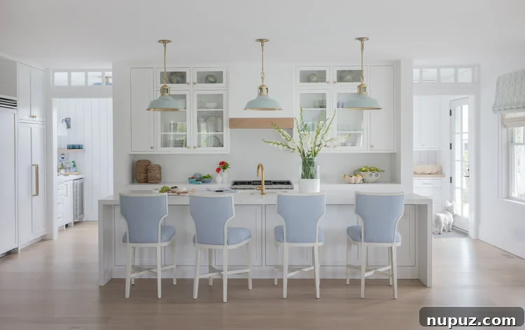 White kitchen with blue counter stools and blue pendant lights